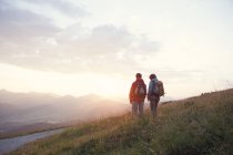 Austria, Tirol, pareja de senderismo en Unterberghorn al amanecer - foto de stock