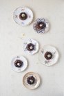 Підвищені подання міні-шоколад тістечка з харчову квіти на тарілки — стокове фото