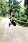 Spain, Oviedo, young woman jumping rope in the park — Stock Photo