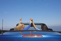 Due donne mano nella mano in una decappottabile — Foto stock