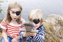 Ragazzo e ragazza vestiti da pirati su una roccia — Foto stock