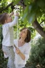 Mãe ajudando seu filho subindo uma escada de corda — Fotografia de Stock
