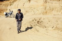 Uomo maturo con moto in pozzo di sabbia — Foto stock