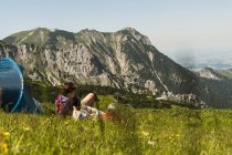 Österreich, Tirol, Tannheimer Tal, junges Paar ruht sich neben Zelt auf Alm aus — Stockfoto