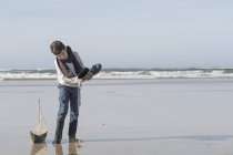 South Africa, Witsand, boy playing with toy sailing boat on the beach — Stock Photo
