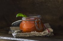 Fresh tomato soup with basil in preserving jar — Stock Photo