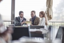 Tres personas teniendo una reunión en el restaurante - foto de stock