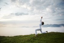 Austria.Kranzhorn, Mid donna adulta che pratica yoga in cima alla montagna — Foto stock