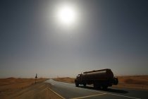 United Arab Emirates, Abu Dhabi, Desert, truck on road against sun — Stock Photo