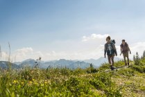 Áustria, Tirol, Tannheimer Tal, jovem casal caminhando na trilha da montanha — Fotografia de Stock