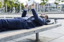 Giovane uomo d'affari sdraiato sul banco, al lavoro — Foto stock
