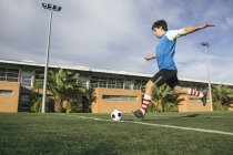 Jugador de fútbol pateando una pelota - foto de stock