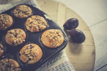 Muffin di prugna a vassoio di muffin con prugne fresche — Foto stock