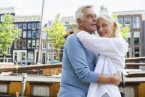 Netherlands, Amsterdam, happy senior couple embracing — Stock Photo