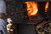 Hombre usando un horno en una fábrica de vidrio - foto de stock