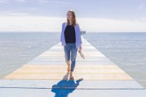 Young woman walking on jetty — Stock Photo