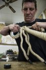 Man adjusting the tension of a rope — Stock Photo
