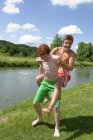 Teenage boy giving friend a piggy back ride in nature — Stock Photo