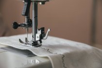 Máquina de coser coser en un paño blanco - foto de stock