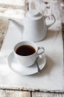 Tazza di caffè nero e caffettiera su legno — Foto stock