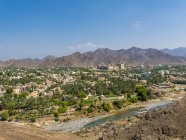 Omán, Dhakiliya, ciudad de Oasis Bahla, Fort Bahal en el fondo, montañas Al Hajar al Gharbi - foto de stock