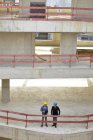Deux hommes avec des chapeaux durs parlent sur le chantier de construction — Photo de stock