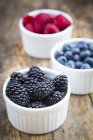 Bowl of fresh blackberries on dark wood — Stock Photo