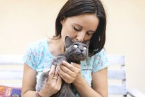 Frau küsst russische blaue Katze — Stockfoto