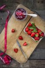 Glass of homemade strawberry jam, ribbon and box of strawberries — Stock Photo
