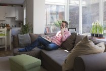 Mature man sitting on couch talking on the phone — Stock Photo