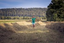 Menina correndo em um campo de feno — Fotografia de Stock