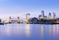 Reino Unido, Londres, horizonte con el río Támesis y Tower Bridge a la hora azul - foto de stock