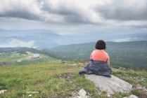 Bulgaria, Monti Rila, vista posteriore di una donna anziana seduta su una roccia guardando la vista — Foto stock