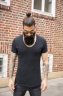 Portrait of young man with full beard, bun and tatooed arms — Stock Photo