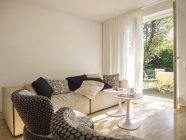 Moderno salón interior y vista parcial al jardín - foto de stock