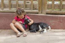 Niña acariciando una cabra - foto de stock