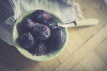 Frische Pflaumen in Schüssel mit Messer — Stockfoto