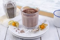Verre de pudding au chocolat avec des graines de chia saupoudrées de rasage au chocolat — Photo de stock
