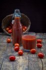 Bicchiere e bottiglia di succo di pomodoro e pomodori — Foto stock