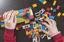 Kinderhände spielen mit Bausteinen auf einem Tisch — Stockfoto