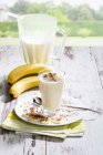 Склянка бананового молочного коктейлю зі збитими вершками та шоколадними гранулами — стокове фото