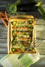 Vegetarian quiche with different vegetables on wood with ingredients — Stock Photo