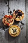 Closeup of three different tarts placed on wood — Stock Photo