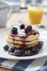 Lemon blueberry pancakes with blueberry syrup — Stock Photo