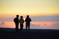 EUA, Havaí, Ilha Grande, Parque Nacional dos Vulcões, três pessoas assistindo ao pôr do sol em Kilauea Iki — Fotografia de Stock