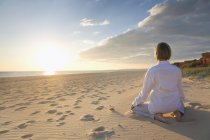 Portogallo, Algarve, donna che fa esercizi di yoga sulla spiaggia al tramonto — Foto stock