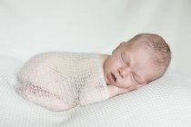 Portrait of sleeping newborn on white blanket — Stock Photo
