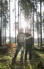 Alemanha, dois amigos de pé de braço dado em uma floresta — Fotografia de Stock