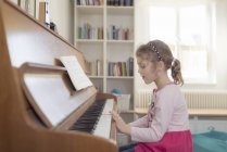 Little girl playing piano at home — Stock Photo