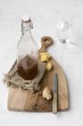 Glass bottle of ginger syrup on chopping board — Stock Photo